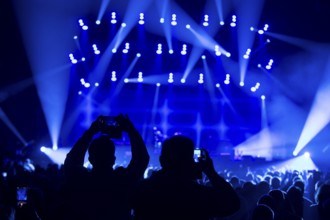 Two concertgoers photograph Sting (civil: Gordon Matthew Thomas Sumner, CBE) live with their mobile