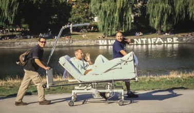 DEU Germany Germany Berlin Two men drive their friend on a hospital bed along the Landwehr Canal