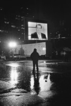 DEU, Germany, Berlin, 22.09.2002, Man in the rain watching Gerhard Schröder on a large screen