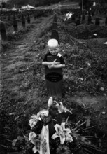 BIH, Bosnia, Screbrenica, 10.07.2005, A boy hugs a Muslim grave cross
