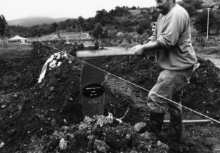 BIH, Bosnia, Screbrenica, 10.07.2005, Man punches a Muslim grave cross into the ground