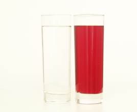 Two glasses of red and transparent liquid on white background, São Paulo, Brazil
