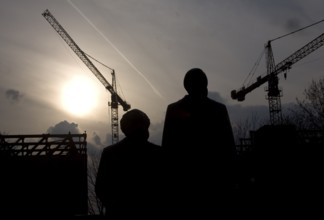 The statues of Marx and Engels stand against cranes demolishing the Palace of the Republic
