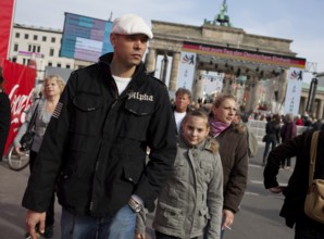 DEU Germany Berlin People stroll in front of the Brandenburg Gate. Scene on the eve of the 20th