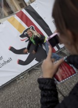 DEU Germany Berlin Girls take pictures of themselves in front of a poster with the Berlin Bear.