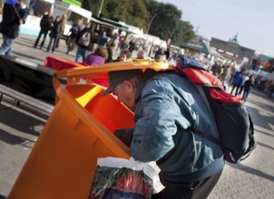DEU Germany Berlin A collector checks the garbage cans for recyclable materials. Scene on the eve