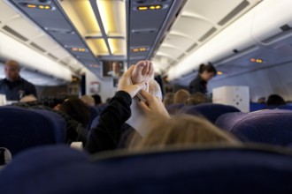 DEU Germany Berlin A passenger stretches her support stocking during an Air Berlin flight to the