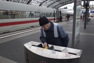 Berlin 2010-11-24 A man searches for recyclable materials in trash cans at Berlin Central Station.