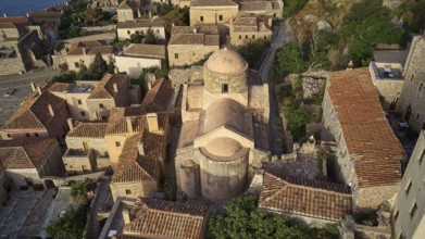 Drone view, aerial view of a compact church structure with domed roof, surrounded by traditional