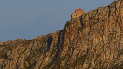 Orhodox church of Hagia Sophia, secluded monastery buildings on rough rocks, illuminated by the