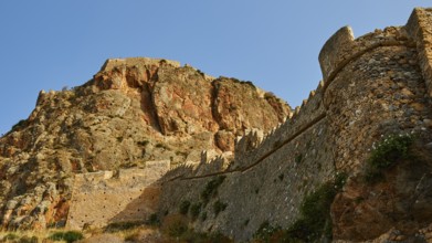 Mighty old city wall wraps around a dramatic rocky landscape, Monemvasia, Monemvassia, Malvasy,