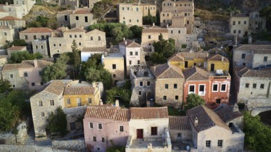 Drone shot, view of a colorful old town with densely packed houses and lush gardens, Monemvasia,