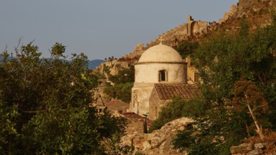 Soft morning light, small church surrounded by ruins and vegetation on a rock at morning light,