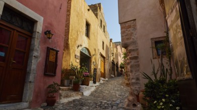 Soft morning light, picturesque street with flowers and old architecture in warm light, Monemvasia,