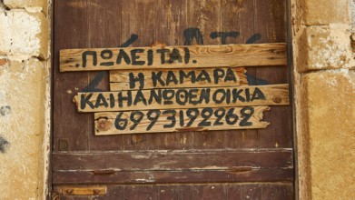 Old wooden door with Greek writing fixed on wooden slats, Monemvasia, Monemvassia, Malvasy, small