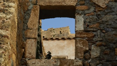 Soft morning light, view through an old window of a ruin with clear blue sky, Monemvasia,