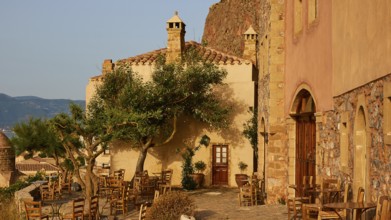 Soft morning light, cozy open-air café with rustic charm and historic buildings at sunrise,
