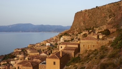 Soft morning light, traditional Mediterranean buildings on a rock overlooking the coastline in