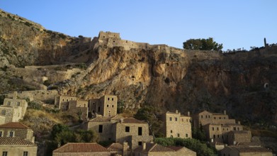 Drone shot, medieval buildings on a rocky cliff overlooking the Mediterranean Sea at sunset,