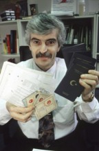 Berlin, DEU, 10.11.1998 -- portrait of Diyap Sarkalli holding Turkish passports and other documents
