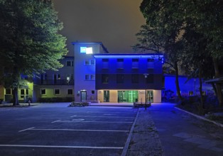 Blue-illuminated Berlin City Mission at night, Berlin, Germany