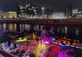 Nightlife on Ludwig-Erhard-Ufer in an outdoor restaurant with the Spree and Berlin Central Station