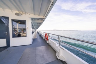 Side of a ship with lifebuoy, looking out over the sea on a clear blue day, boat trip, Lake
