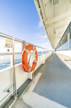 Side view from a ship deck with lifebuoy, calm sea and sunny sky, boat trip, Lake Constance,