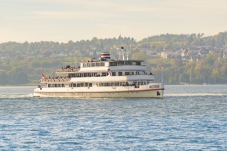 Large passenger ship on a lake with city and nature in the background, boat trip, Lake Constance,