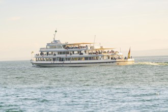 Large passenger ship full of people on calm water under a sunny sky, boat trip, Lake Constance,
