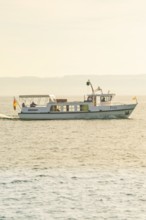Boat sails towards the horizon on the lake at sunset, boat trip, Lake Constance, Germany