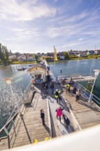 People at a pier in sunny autumn weather, boat trip, Lake Constance, Germany