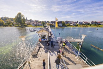 Wide angle view of pier with village in background, boat trip, Lake Constance, Germany
