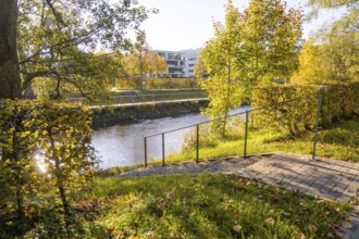 Autumn river trail with railings and surrounding trees, Nagold, Black Forest, Germany