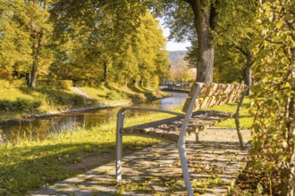 Inviting sitting area in a sunny park with a view of a river and autumn trees, Nagold, Black