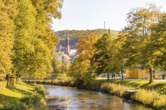 Autumn river landscape with a church and colorful trees in the background, Nagold, Black Forest,