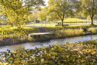 Autumn park on the river with a jetty and trees, Nagold, Black Forest, Germany