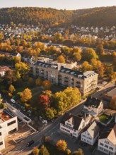 Autumn view from above of a city surrounded by trees and hills, in warm sunlight, Nagold, Black