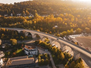 A viaduct in an autumnal landscape, surrounded by nature and a small village, Nagold, Black Forest,