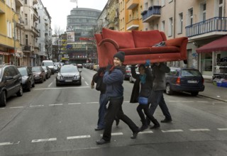 DEU Berlin Young people carry a sofa across Fuldastraße in Berlin Neukölln. The former problem