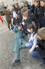 DEU Berlin A man disguised as a GDR soldier during a group photo in front of the Brandenburg Gate.