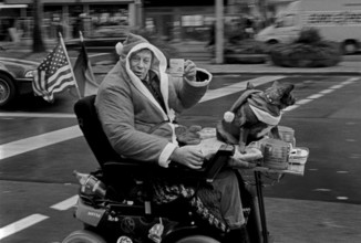 DEU, Germany, Berlin, 14.12.2003, A well-known homeless person cheers from his wheelchair with