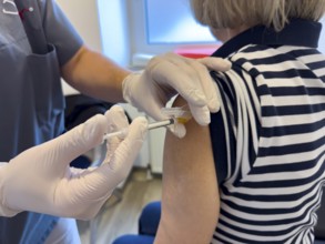 Patient woman receives injection in upper arm for vaccination against contagious disease flu flu