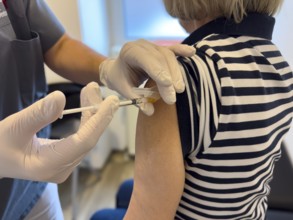 Patient woman receives injection in upper arm for vaccination against contagious disease flu flu