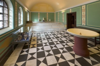 Reconstructed Roman ancient caldarium hot bath heating room with hot water pool in the background