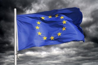 European Union flag waving against dark sky, photo montage