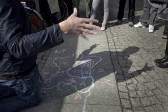 DEU Berlin A tourist guide explains the division of Germany with a circle drawing at Checkpoint