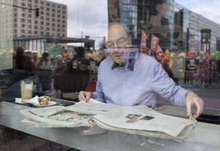 Germany Berlin Anti-nuclear power demonstration in Berlin Mitte. Visitor reads newspapers in a