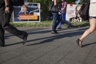 DEU Germany Germany Berlin Pedestrians pass the election posters of Angela Merkel CDU and Peer