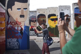 DEU Germany Germany Berlin A tourist has himself photographed shooting in front of Syrian dictator